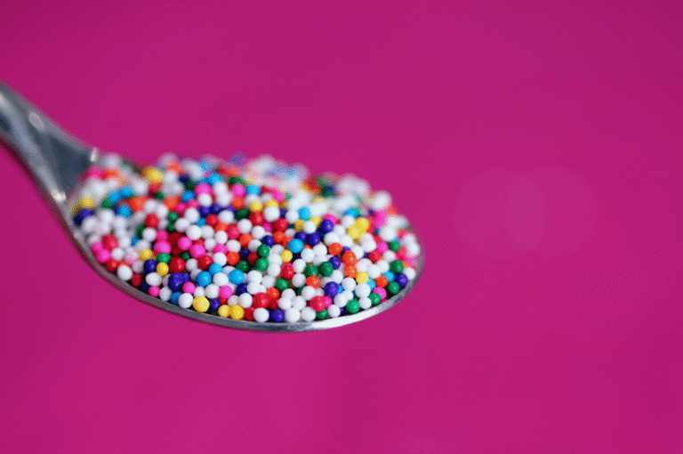 Edit with Confidence - image of a steel spoon holding multi-coloured hundreds and thousands.