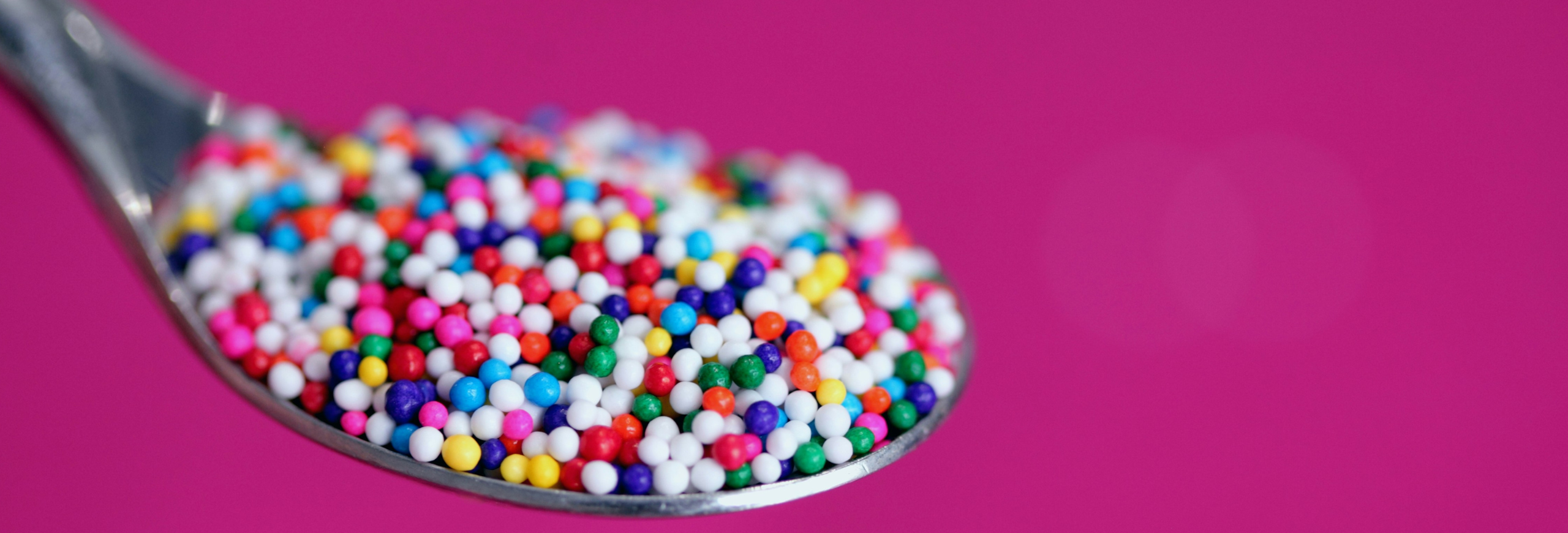 Edit with Confidence - image of a steel spoon holding multi-coloured hundreds and thousands.