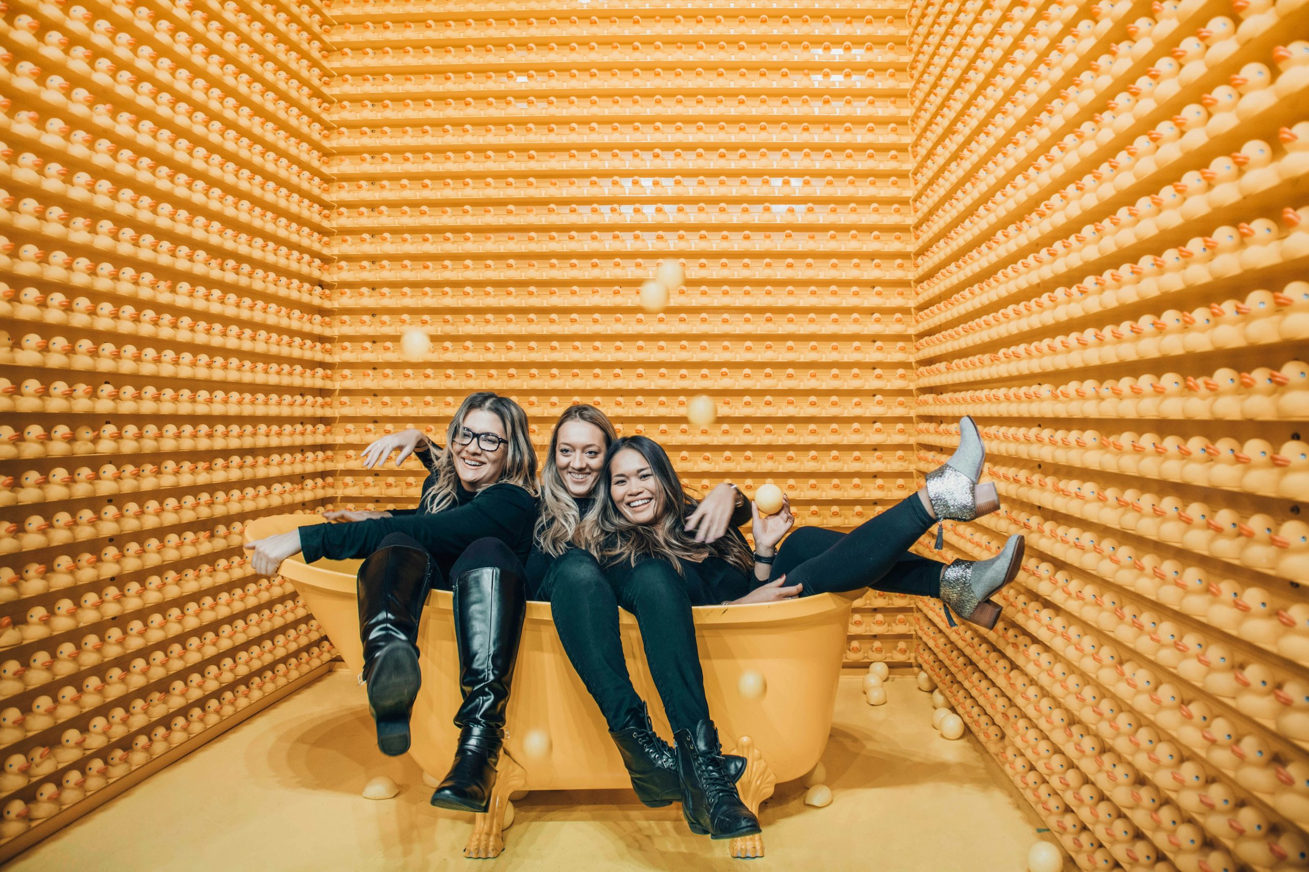 Why collaboration should be part of your marketing plan (especially when the budget’s tight) - image of 3 women in black squeezed into an orange bathtub