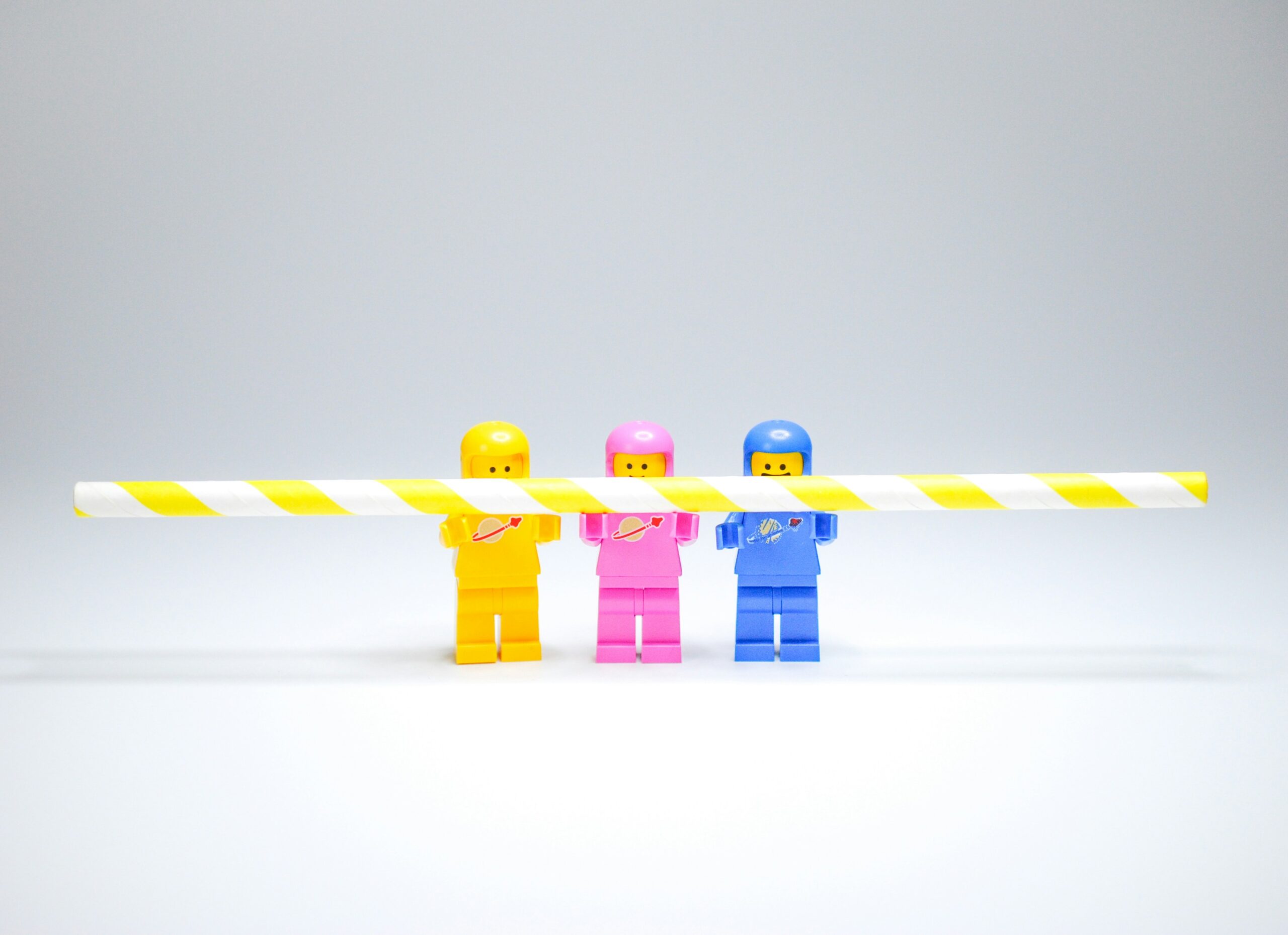 Marketing support for small businesses that don’t want an agency - image of 3 Lego minifigs working holding a long yellow and white straw