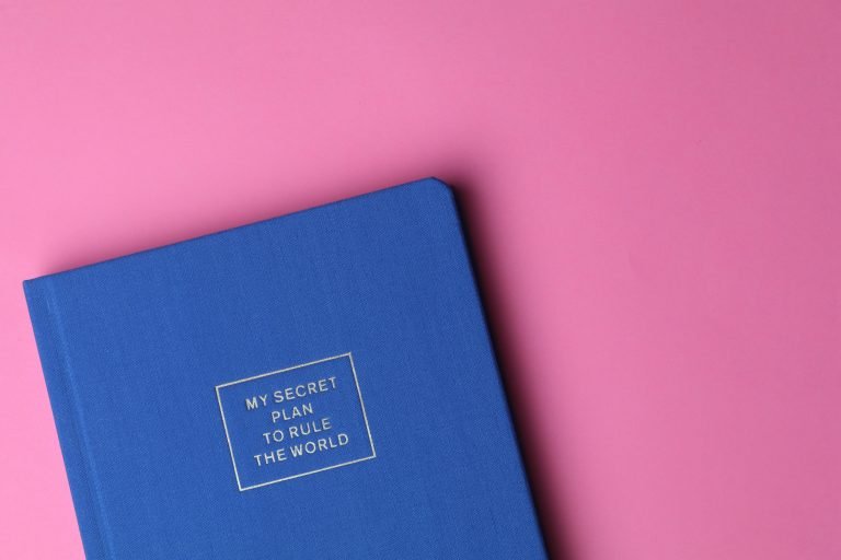How to use marketing data in your business planning - image of a blue notebook on a pink background